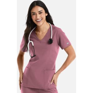 A woman in a pink double V-neck top wearing a stethoscope, with two pockets visible. The top has a logo.