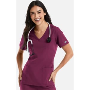 A woman wearing a burgundy double V-neck top with a stethoscope around her neck and pockets on the front.