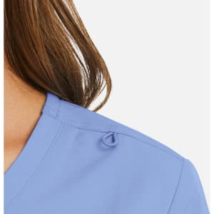 A women's mock wrap top in light blue with a loop detail on the shoulder. Features a sleek neckline design.