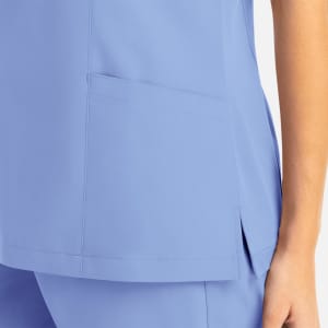 A mock wrap top in light blue featuring a side pocket and a sleek design. It has a logo on the fabric.
