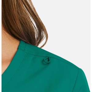A close-up of a teal women's mock wrap top featuring a unique shoulder detail and a logo.