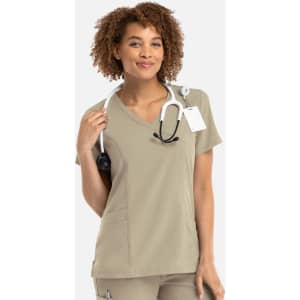A women's mock wrap top in beige, featuring a V-neck design and a logo, styled with a stethoscope.