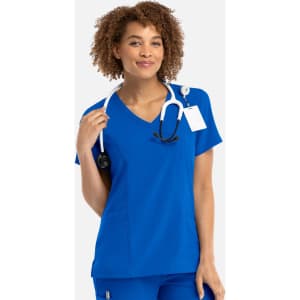 A woman wearing a vibrant blue mock wrap top, holding a stethoscope, featuring a logo on the design.