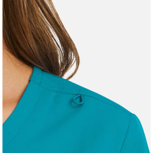 A woman's mock wrap top in vibrant teal, featuring a loop detail on the shoulder and a smooth fabric texture.