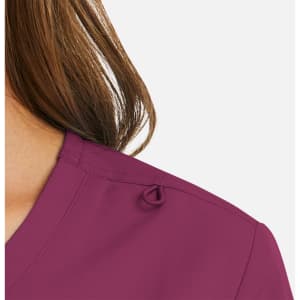 A close-up of a women's mock wrap top in a rich plum colour, featuring a loop detail on the shoulder.