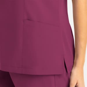 A magenta women's mock wrap top featuring a side pocket and a sleek design. The fabric has a smooth finish.