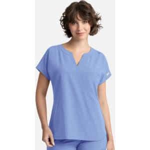 A women's dolman top in light blue with a V-neck, short sleeves, and a front pocket. It features branding.