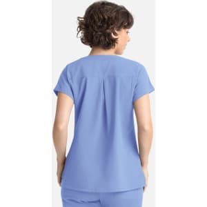 A relaxed-fit women's top in light blue with short sleeves and a back pleat. It features a logo on the side.
