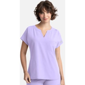 A lilac women's dolman top featuring a v-neck, short sleeves, and a pocket, with a subtle logo.