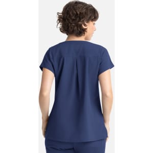 A navy women's top with short sleeves and a back pleat design, featuring three pockets and a branding logo.