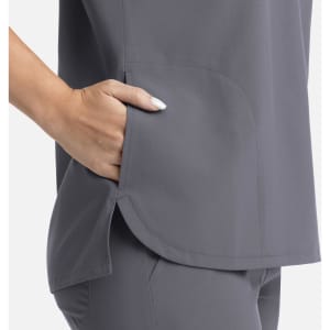 A grey women's top features a rounded hem and a side pocket, showcasing a sleek and comfortable design.