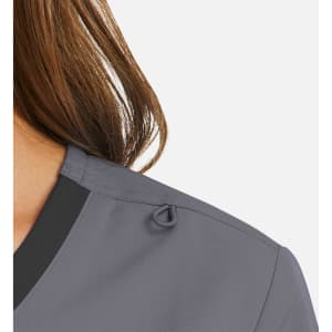 A mock wrap top in grey with a contrast trim, featuring a small loop detail on the shoulder.