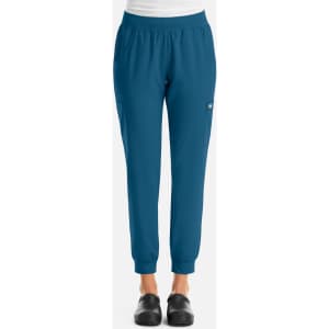 A pair of women's joggers in a teal colour with a fitted waist and elastic cuffs, featuring a logo.