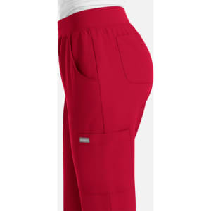 A red jogger pant with an elastic waistband and side pockets, featuring a small logo on the pocket.