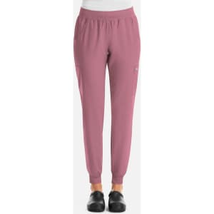 A pair of women's jogger pants in a soft pink hue with elastic cuffs and pockets. Features a logo on the side.