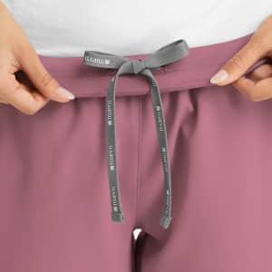 A pair of women's joggers in a mauve colour, featuring a grey drawstring at the waistband and a logo.