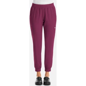 A pair of women's joggers in a vibrant burgundy colour with an elastic waistband and pockets, featuring a logo.