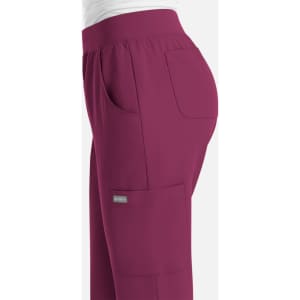A pair of women's joggers in a rich burgundy colour, featuring a side pocket and an elastic waistband.