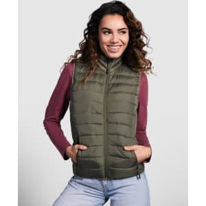 A woman models an olive green padded vest, featuring a zip front and side pockets, paired with a burgundy long-sleeve top.