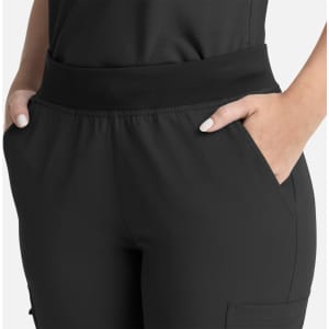 A close-up of women's black flare leg pants featuring a full elastic band and side pockets.