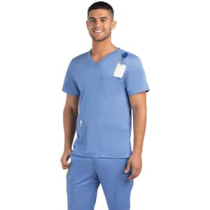 A man wearing a blue V-neck top with three pockets, featuring a logo and a tag.