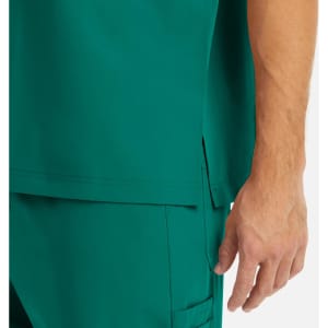 A close-up of a men's tuckable v-neck top in teal, featuring a side slit and a hand resting on the fabric.