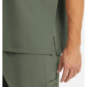 A close-up of a men's tuckable V-neck top in olive green, showing the fabric and a hand near the hem.