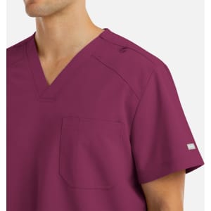 A men's v-neck top in a deep burgundy colour with a chest pocket and shoulder detail, featuring a logo.