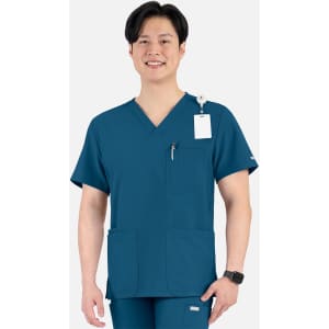 A man wearing a teal V-neck top featuring four pockets and a logo, smiling against a plain background.