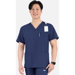 A navy V-neck top with four pockets, featuring a logo and a tag, worn by a smiling male model.