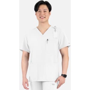 A man in a white V-neck top featuring four pockets and a logo, smiling against a plain background.
