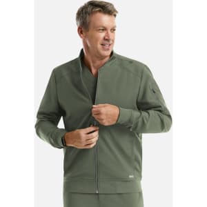 A man in an olive green full zip bomber jacket with a logo on the sleeve, smiling.