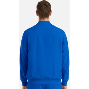 A man in a blue full zip bomber jacket, viewed from the back, featuring a subtle branding logo.