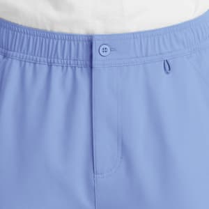 A pair of blue cargo pants featuring a fly front closure and an elastic waistband. The design includes pockets and a logo.