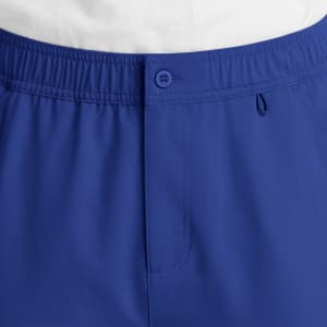 A pair of blue cargo pants featuring a fly front, button closure, and an elastic waistband. It has a logo.