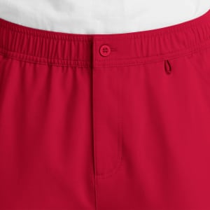 Red cargo pants featuring a fly front, elastic waistband, and a button closure. Includes a logo detail.