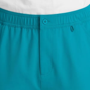A close-up of men's cargo pants in a vibrant teal colour, featuring a fly front and elastic waistband.
