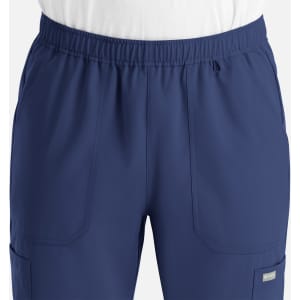 A pair of navy blue men's joggers featuring a full elastic waistband and pockets. The product includes a logo.