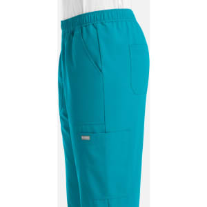 Full elastic jogger in teal, featuring side pockets and a logo on the thigh.