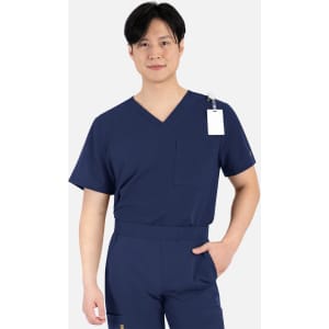 A man wearing a navy blue V-neck top with short sleeves and a pocket. The top has a tag attached.