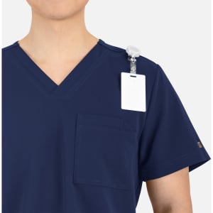 A navy V-neck top with contrast piping and a chest pocket, featuring a badge holder on the shoulder.