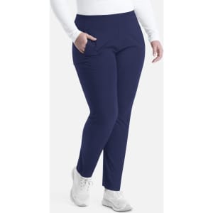 A pair of navy mid-rise tapered pants featuring a snug fit and side pockets, modelled by a person in white attire.