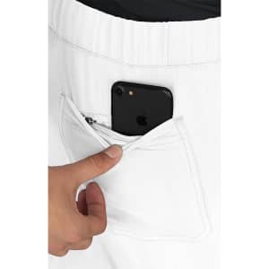 A hand placing a smartphone into the pocket of white trousers featuring an elastic waistband.
