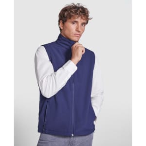 A navy softshell vest with a high collar, featuring a zip front and side pockets, worn by a model.