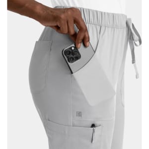 A pair of light grey cargo pants with an elastic waistband, featuring side pockets and a phone being placed in one pocket.