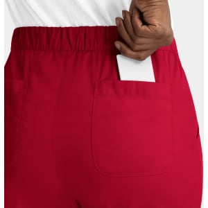 A pair of red cargo pants featuring a full elastic waistband and a back pocket holding a white card.