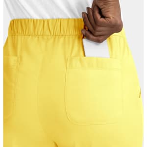 A pair of yellow women's cargo pants featuring a full elastic waistband and a pocket with a phone partially placed inside.