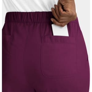 A pair of purple cargo pants with a full elastic waistband, featuring a pocket on the back with a white card.