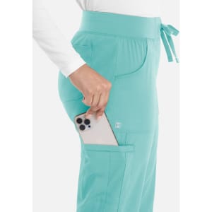 A pair of teal women's joggers featuring pockets and a drawstring waist, with a phone being placed in one pocket.