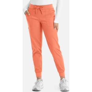 A pair of women's jogger pants in coral with a drawstring waist and side pockets, featuring a branded logo.